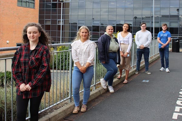 Six students outside Downpatrick Campus celebrate results.